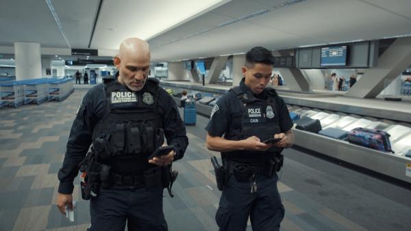 Bild 1 von 2: Officer Chun und sein Kollege vom US-Grenzschutz fahnden am Flughafen SFO nach einem Mann aus Südkorea, der sich an einem Luftwaffenstützpunkt in Montana verdächtig verhalten hat.