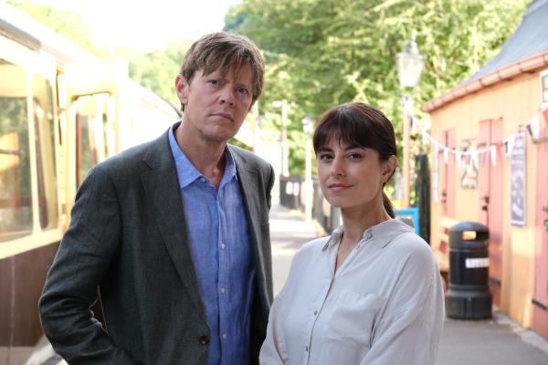 Bild 1 von 3: DI Humphrey Goodman (Kris Marshall) und DS Esther Williams (Zahra Ahmadi) sind bei Proben der Amateur-Theatergruppe von Shipton Abbott als Ersatzleute eingesprungen.