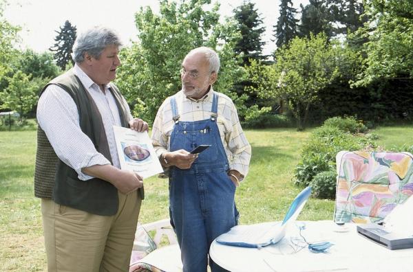 Bild 1 von 2: Nachbar Paschulke (Helmut Krauss, l.) ist empört- ausgerechnet auf sein Auto hat ein Schmierfink dieses rätselhafte Zeichen gemalt. Was mag es wohl bedeuten? Auch Peter (Peter Lustig, r.) weiß zunächst keine Antwort.